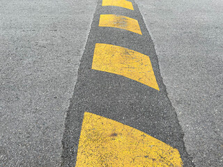 Wall Mural - Vertical striped black and yellow asphalt speed hump and bump.