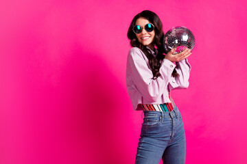 Sticker - Photo of optimistic brunette lady hold ball look empty space wear spectacles top jeans jacket isolated on pink background