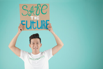 Wall Mural - Portrait of cheerful young Vietnamese man asking people to save the future, isolated on turquoise