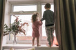 © Myroslava - Happy children standing on the windowsill, looking through the window. Little girl and boy.