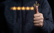 © Dilok - Hand and thumb rise up with five yellow stars on black background, Best customer satisfaction and evaluation for good quality product and service.