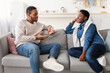 © Prostock-studio - Black couple talking and spending time together sitting on couch