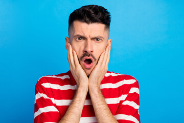 Sticker - Photo of shocked impressed young man wear striped t-shirt arms cheeks open mouth isolated blue color background