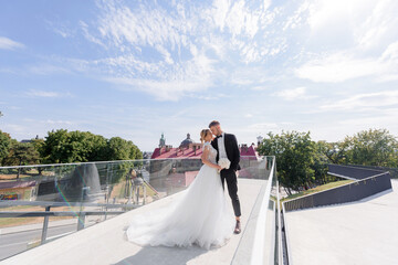 From a distance view of beautiful newlyweds hugging on the urban background.