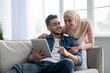 © Prostock-studio - Young muslim couple using mobile app on digital tablet