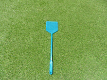 Fly Swatter On Grass In The Sunlight

