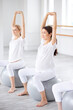 © Roman - group of young pretty pregnant women in sportive outfit stretching body in studio