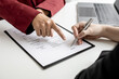 © kamiphotos - The HR department is pointing to the documents for the job applicant to sign on the contract after attending a job interview with the department manager and being selected for the job.