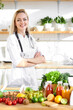 © Roman - Portrait of young smiling female nutritionist in consultation room. desk with healthy fresh food