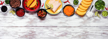 Taco Bar Top Border With An Assortment Of Ingredients. Overhead View On A Rustic White Wood Banner Background. Mexican Food Buffet. Copy Space.