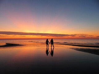 Wall Mural - silhouette of a person walking on the beach