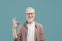 Everything Is Okay. Joyful Albino Guy Doing Approval Ok Gesture With Fingers, Showing That He Is Fine, Blue Studio Background