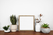 Mock Up Wood Square Frame With A Variety Of Houseplants And Branches. Wooden Shelf Against A White Wall. Copy Space.