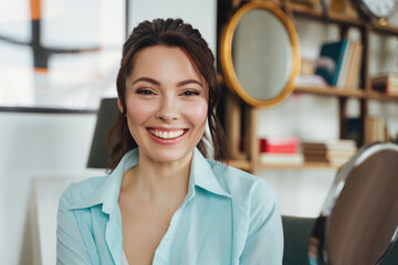 Wall Mural - Happy beautiful woman in the house posing near the mirror, looking at the camera with a smile