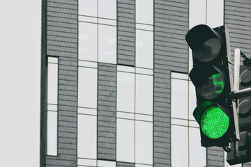 Traffic light on the background of the building. Traffic light green. Countdown