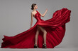 © Alena - Fashion woman in red long dress. Gray background