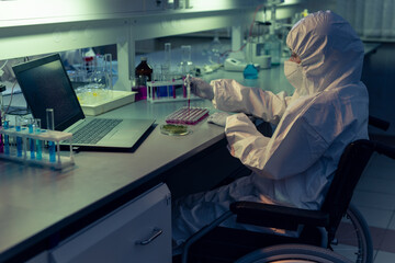 Sticker - Disabled chemist in protective workwear and mask examining liquid in test tubes at the table in the lab