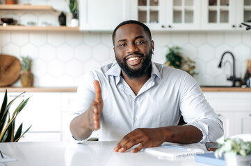 Wall Mural - Attractive influential confident African American bearded man, broker, manager or business leader, stretches out his hand for a handshake with a partner, concluding a deal, signing an agreement, smile