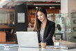 © amnaj - Asian businesswoman sitting work on a laptop at the office.
