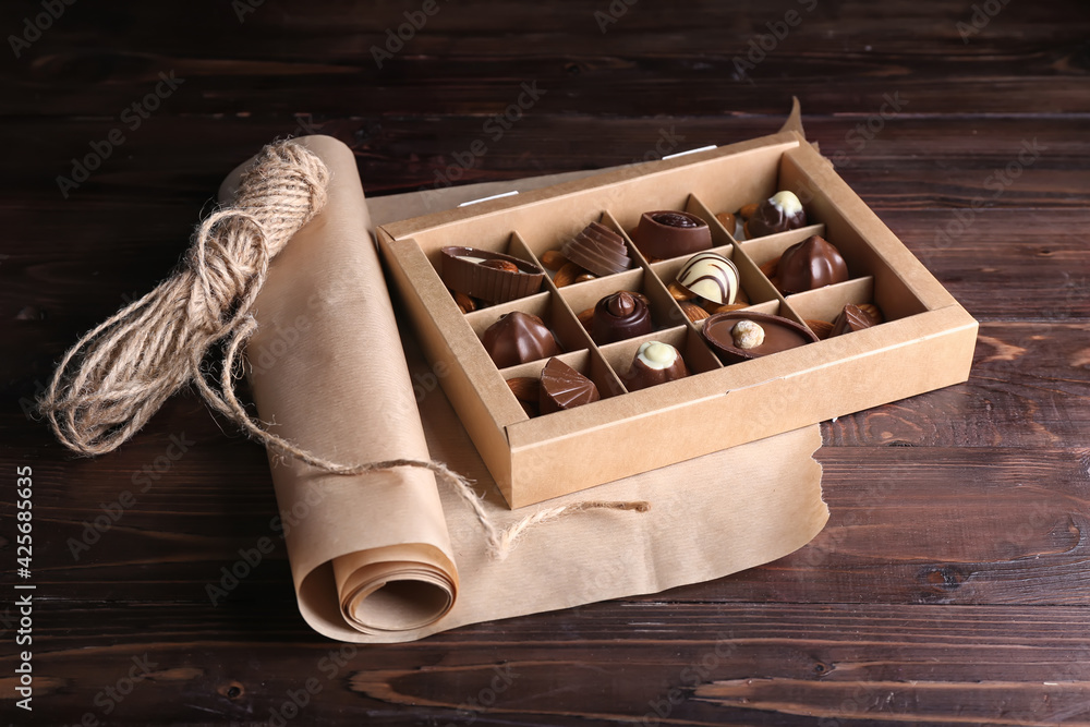 Box with tasty chocolate candies on table