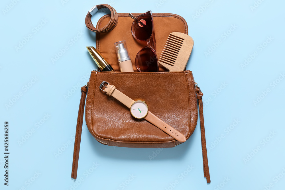 Stylish female accessories on color background