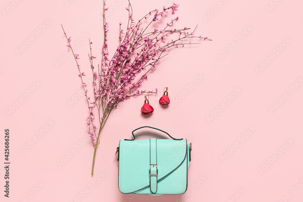 Stylish female accessories with flowers on color background