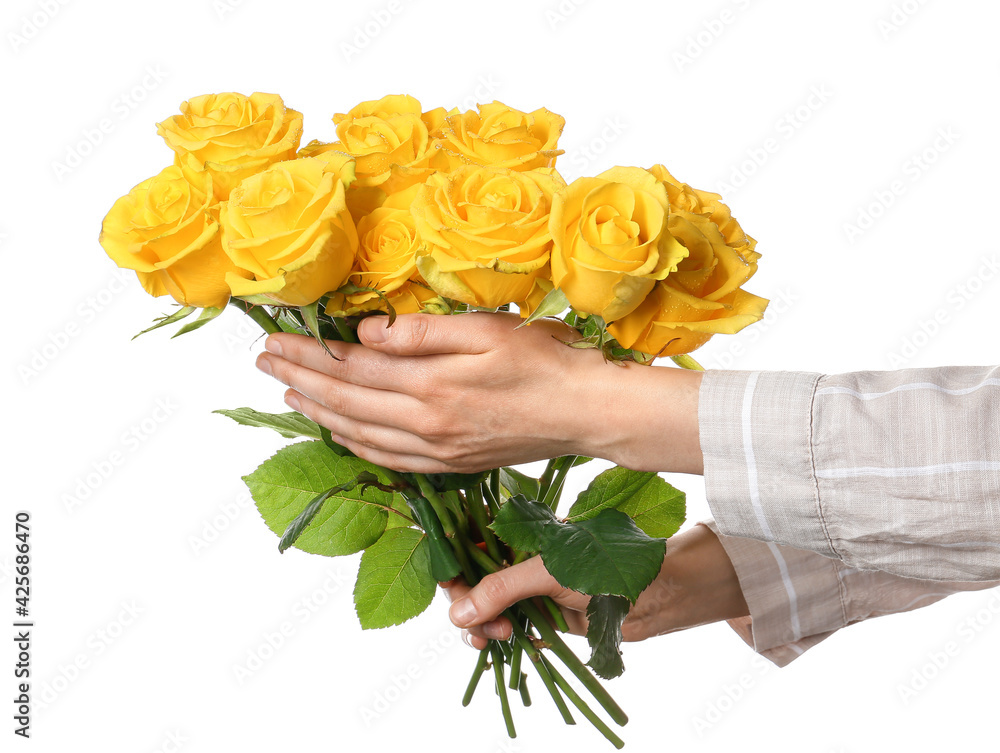 Female hands with fresh yellow roses on white background