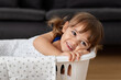 © Lisa Tichané - Portrait of smiling toddler lying in laundry basket