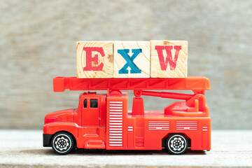 Wall Mural - Fire ladder truck hold letter block in word EXW (abbreviation of Ex works) on wood background