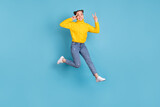 Fototapeta  - Full length photo of cheerful person jump fingers show v-sign near eye isolated on blue color background