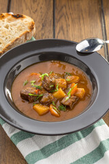 Wall Mural - beef stew with bread toast in grey plate on wooden table