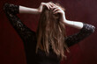© Roman Kornev - Portrait of a young woman with long brown hair, on a red textured background