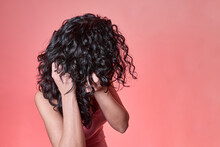 Young Black Curly Haired Woman Combing Her Hair Following Curly Girl Method On Pink Background. Hair Care Concept.