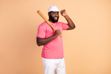 Wall Mural - Photo portrait of man wearing casual outfit cap smiling keeping wooden bat isolated pastel beige color background
