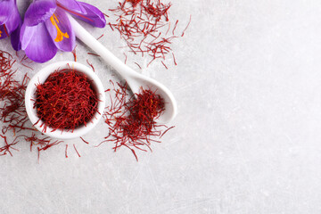 Wall Mural - Dried saffron and crocus flowers on grey table, flat lay. Space for text