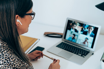 Wall Mural - Close up of businesswoman talking on video call meeting with colleagues during the pandemic period. Smiling business woman discuss with clients or coworkers at online web conference from home
