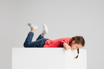 Wall Mural - Happy kid, girl isolated on white studio background. Looks happy, cheerful, sincere. Copyspace. Childhood, education, emotions concept