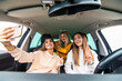 © F8  \ Suport Ukraine - Three women having fun in the car and taking selfies with phone