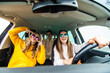 © F8  \ Suport Ukraine - Group of girls having fun in the car, singing songs and dancing in car during road trip.