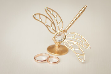 Wall Mural - Wedding rings and statuette of golden butterfly, wedding accessories