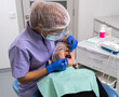 using a dental mirror and a dental probe, the dentist examines the patient's oral cavity.