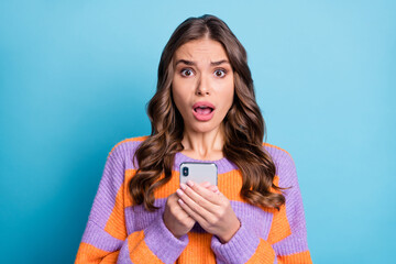 Canvas Print - Portrait of impressed person hold phone open mouth staring camera wear pullover isolated on blue color background