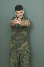 
Young Military Man In A Camouflage Uniform Posing In A Photo Studio