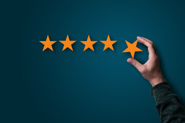 Poster - Hand holding and putting yellow stars for evaluate quality of product and service , customer satisfaction concept.