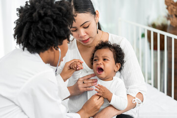 African female pediatrician hold stethoscope exam child boy patient visit doctor with mother