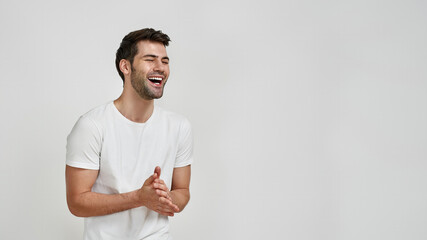 Wall Mural - Happy bearded young man in white t-shirt laughing