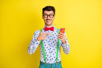 Sticker - Photo of young excited man happy smile point finger cellphone advice recommend isolated over yellow color background