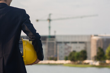 Wall Mural - Technician holding yellow hat safety hard hat sunlight background