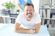 © H_Ko - Portrait of smiling man at proctologist appointment
