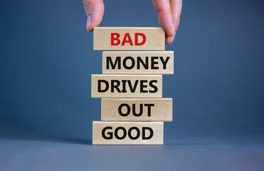 Wall Mural - Business concept growth success process. Wood blocks on grey background, copy space. Businessman hand. Words 'bad money drives out good'. Conceptual image of motivation.